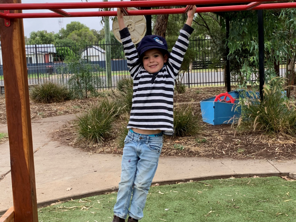 HEADING: Nutrien grant provides improved facilities for children’s occupational therapy. IMAGE: Child on the monkey bars looking at the camera.