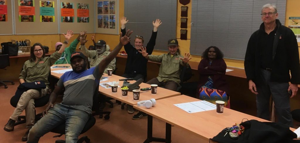 A group of Rangers sit around a table with their hands thrown up in the air