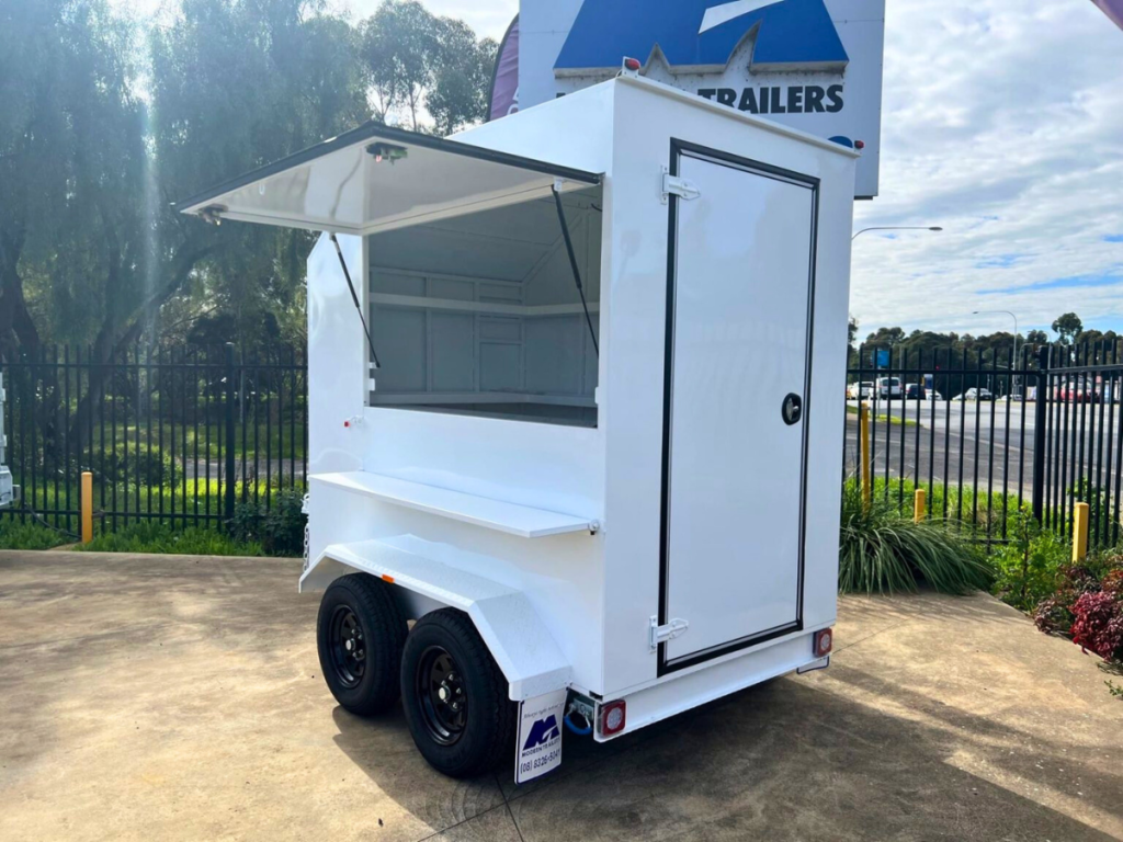A catering trailer with the side window opened.
