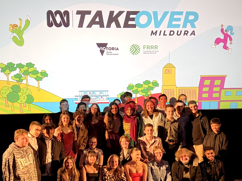 Group of youth on a stage in front of a sign that says 'ABC Takeover Mildura'